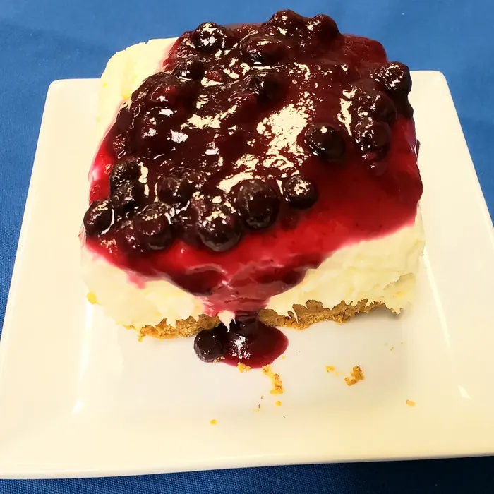 Berries on a Cloud dessert with cheesecake filling and warm berry sauce