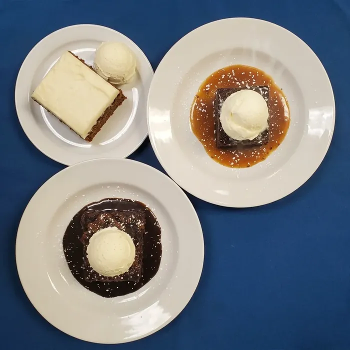 Dessert platter of cheesecake, sticky toffee pudding and chocolate pudding with vanilla ice cream