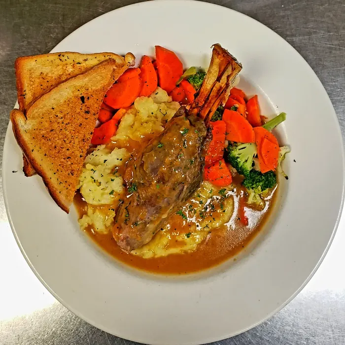 Slow-braised lamb shank with mashed potatoes, vegetables and garlic toast