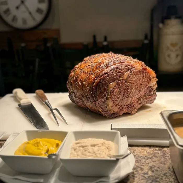Slow-roasted prime rib resting on the carving board with horseradish, grainy mustard and au jus